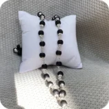 silver plated Karungali mala on white cushion spiritual beads necklace