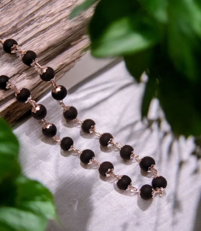 silver-plated-karungali-mala-wood-scenery.webp silver plated Karungali mala with half wood natural scenery background